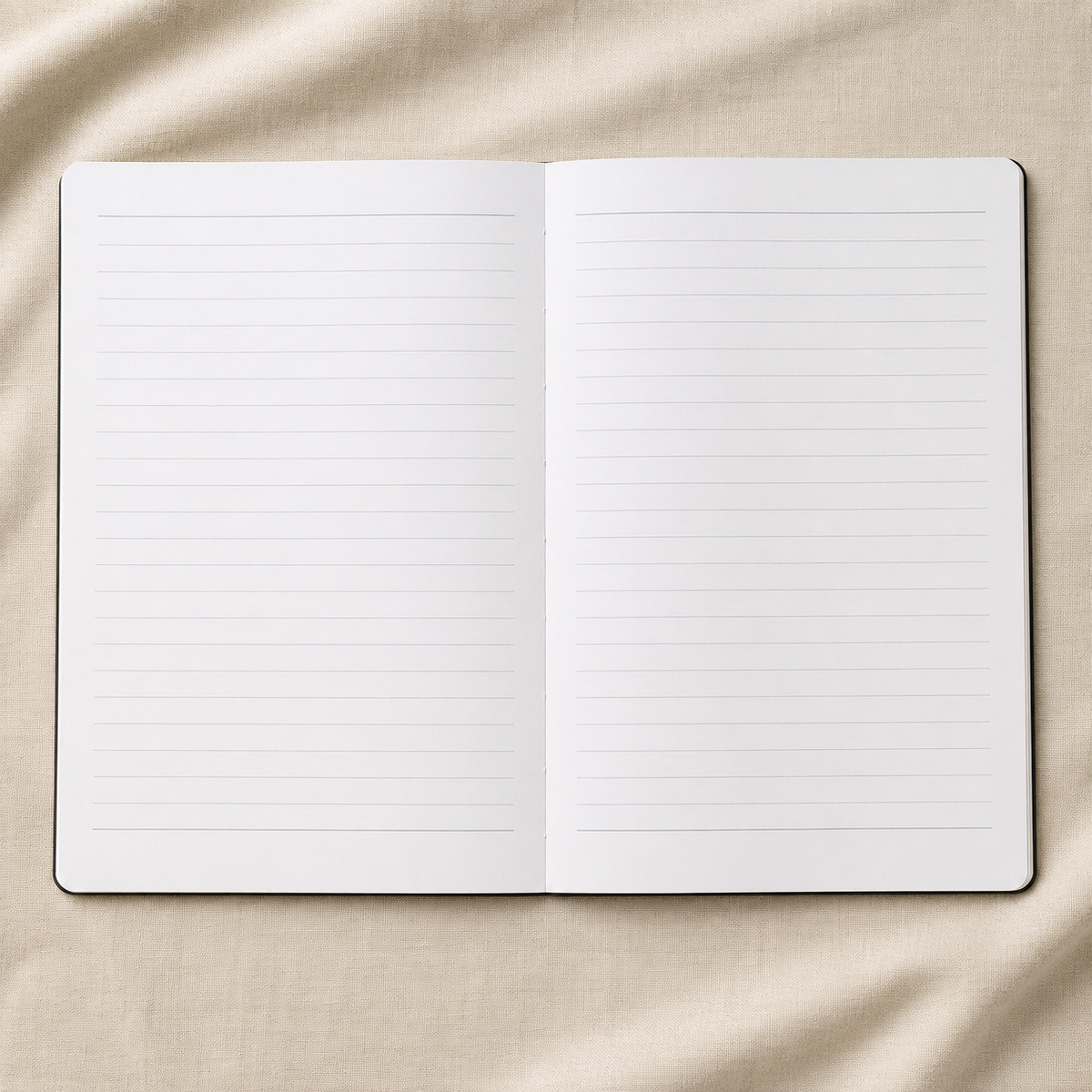 An open lined notebook or journal laid flat on a beige fabric background.